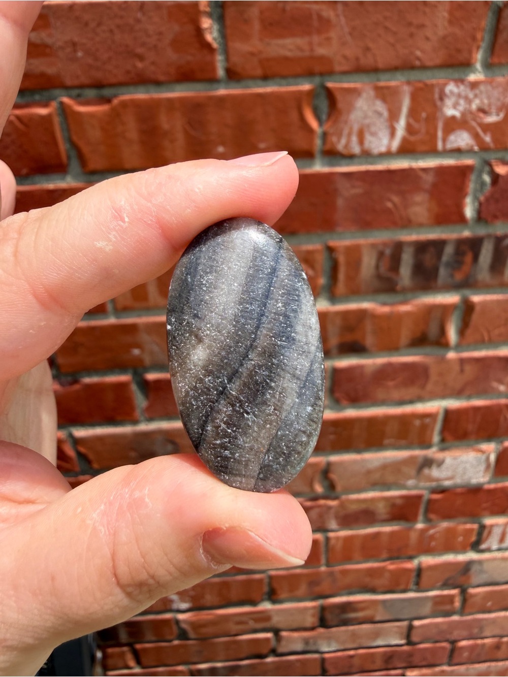 Polished Oval Hand Stone in Gray-Black Striations Calcite Cabochon
